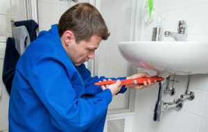 Emergency plumber fixes a leaking sink drain